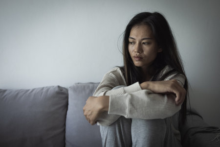 Tired, headache and stress of woman in living room with mental health, fatigue and sad problem. Face, depression and frustrated male person with anxiety, brain fog or crisis of failure.の写真素材