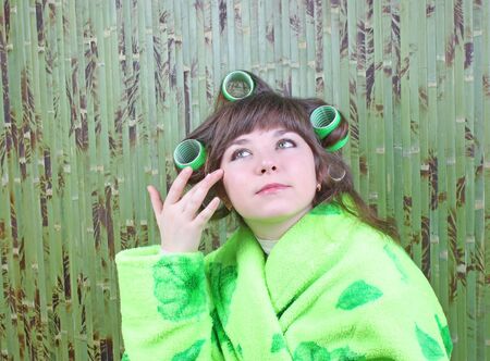 beautiful girl in green dressing gown with rollers hairの写真素材