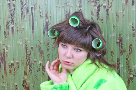 beautiful girl in green dressing gown with rollers hairの写真素材