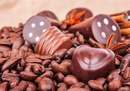 Different sweet chocolate candies with spice on coffee beans background, food photoの写真素材