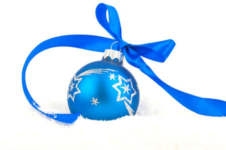 Christmas ball with blue ribbon on snowの写真素材