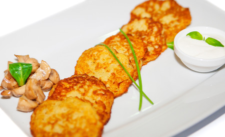 Potato pancakes with sauce and mushroom on plate, restaurant menuの写真素材