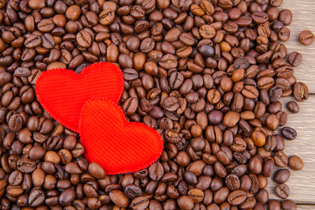 Red two hearts and coffee beans on wooden backgroundの写真素材