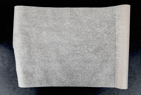 Baking paper on dark kitchen table.