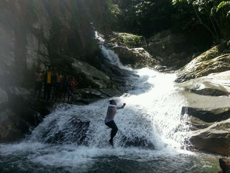 Jumping into waterfall while kids watchingの素材