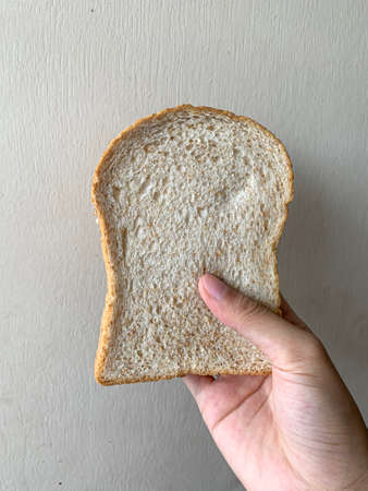 Hand hold slices of bread on white backgroundの写真素材