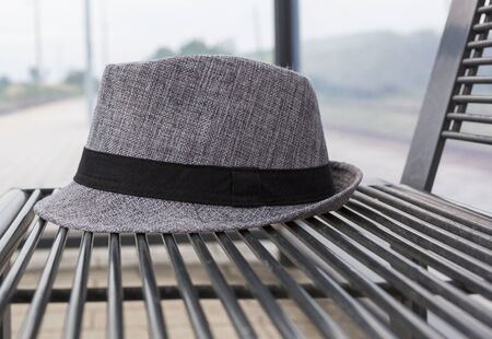 gray hat on metal bench at the train stopの写真素材
