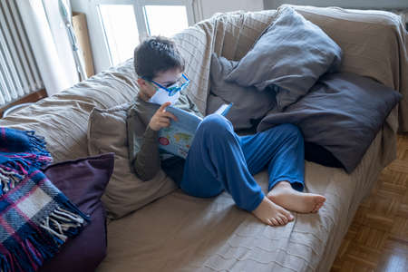 baby italian boy playing with pad digital games at home in corona virus time