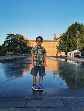 beautiful child in reggio emilia victory square in front of the fountain