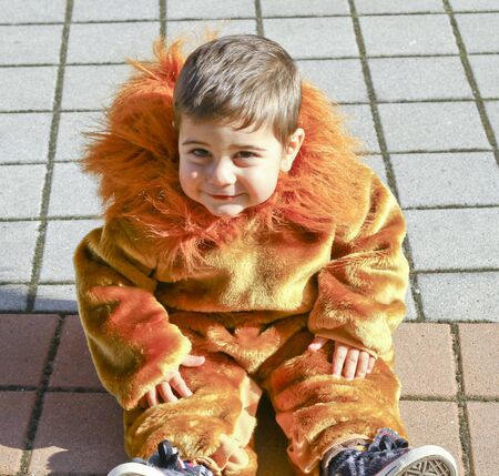 beautiful Italian child at carnival with lion costume with confetti and mane