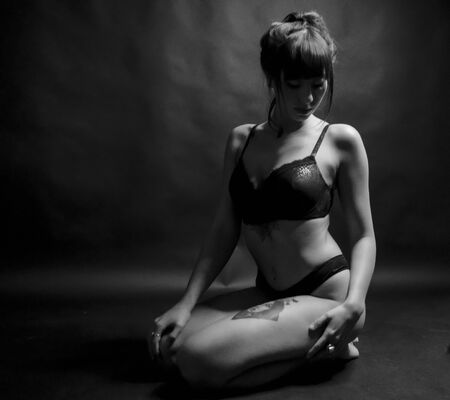beautiful brunette girl with long hair in underwear on her knees in black and whiteの写真素材