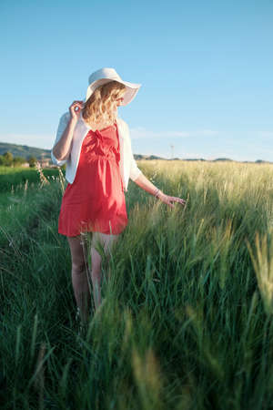 beautiful blonde girl with heavenly dress at sunset in wheat field. High quality photoの写真素材
