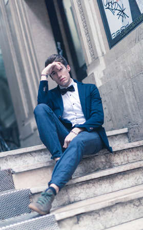 beautiful dark-haired boy poses in the center of reggio emilia with elegant shirt
