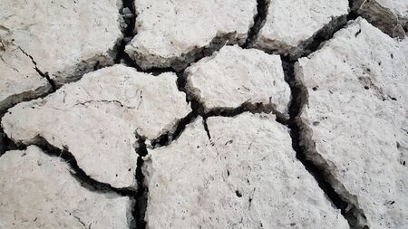 backdrop of dry earth split by the white sun