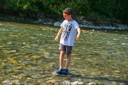 beautiful child plays on the banks of the river enza in reggio emilia italy. High quality photoの写真素材