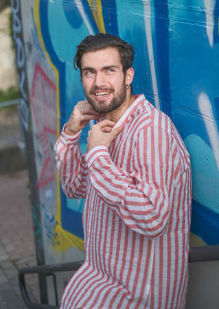 beautiful dark-haired boy in the city center with short pants and striped shirt. High quality photoの写真素材