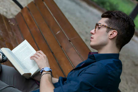 beautiful boy poses among the leaves of a pergola with open shirt and body on display. High quality photoの写真素材