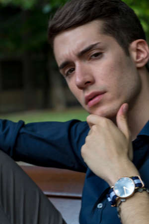 beautiful boy poses among the leaves of a pergola with open shirt and body on display. High quality photoの写真素材