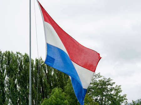 Dutch flag waving over cloudy sky. High quality photo