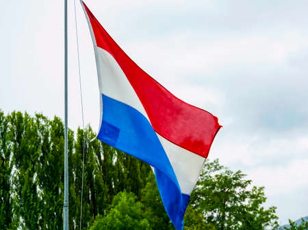 Dutch flag waving over cloudy sky. High quality photo