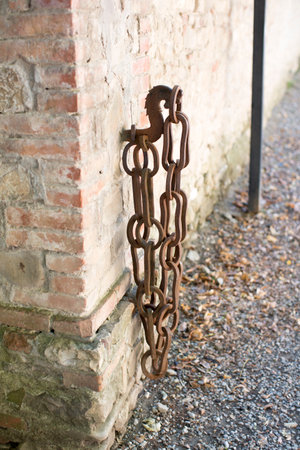 Old rusty chain hanging on a hook on a wall. High quality photo