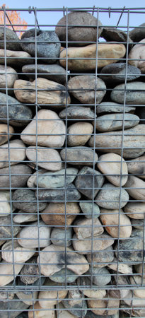 wall of river stones in metal cage. High quality photoの写真素材