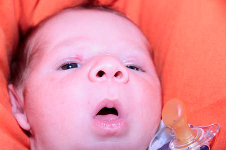 newborn baby yawning on sofa with open mouth. High quality photo