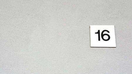 White tile with number sixteen on a wall. High quality photoの写真素材