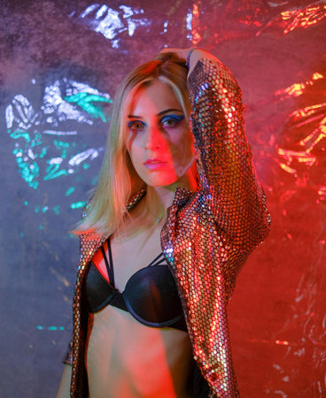 beautiful blonde italian girl posing in photo studio with colorful lights High quality photo