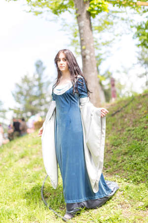 beautiful brunette and blue eyes girl in fantasy medieval clothes strolls through the meadows. High quality photoの写真素材