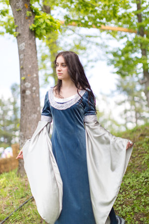 beautiful brunette and blue eyes girl in fantasy medieval clothes strolls through the meadows. High quality photoの写真素材