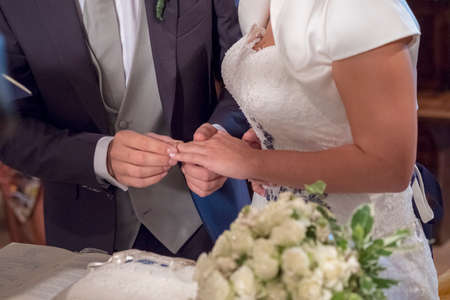 bride puts wedding ring to groom in catholic rite in italy. High quality photoの写真素材