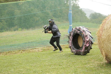 boy plays paintball in equipped woodball field with tires. High quality photoの写真素材
