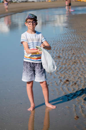 beautiful child collects shells on the beach of Riccione Rimini. High quality photoの写真素材