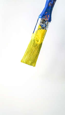 paintbrush with dripping yellow paint on white background. High quality photoの写真素材