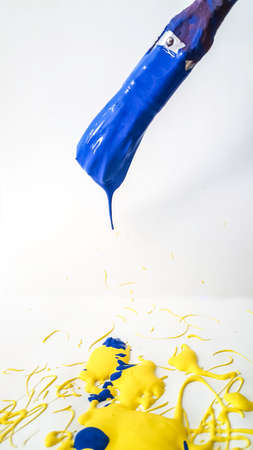 paintbrush with blue paint dripping on white background. High quality photoの写真素材