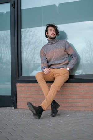 handsome Italian dark-haired boy with striped sweater in the center. High quality photo