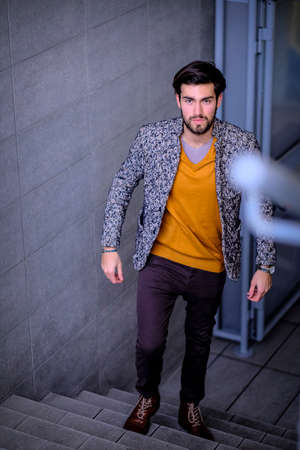 handsome Italian dark-haired guy on the roof of a tall building. High quality photoの写真素材