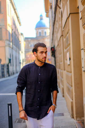 handsome Italian dark-haired guy with blue shirt in town. High quality photoの写真素材
