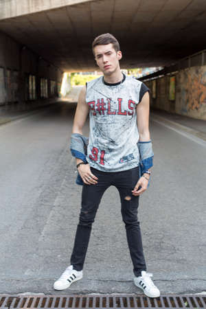 young dark-haired guy in urban landscape. High quality photo
