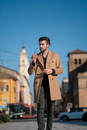 handsome Italian boy walks with coat in the historic center of Parma. High quality photoの写真素材