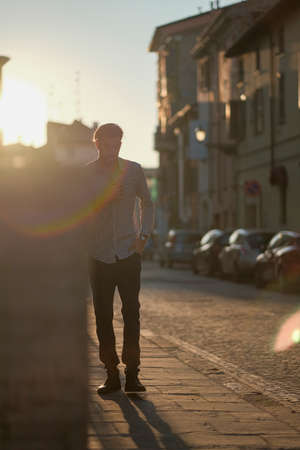 handsome Italian guy poses against the light at sunset. High quality photo