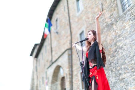Montefiorino Modena, Italy: 2015 05 01 queen's day public event in the square with belly dancer and singer with fans and fabrics. High quality photoのeditorial素材