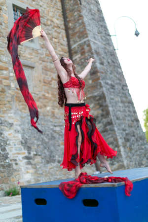 Montefiorino Modena, Italy: 2015 05 01 queen's day public event in the square with belly dancer and singer with fans and fabrics. High quality photoのeditorial素材