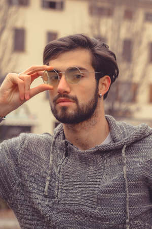portrait handsome Italian dark-haired boy with round yellow glasses. High quality photoの写真素材