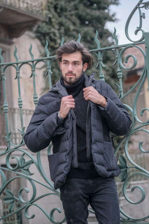 handsome Italian dark-haired boy standing with winter jacket. High quality photoの写真素材
