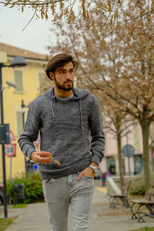 handsome Italian dark-haired boy with sweatshirt strolling. High quality photo