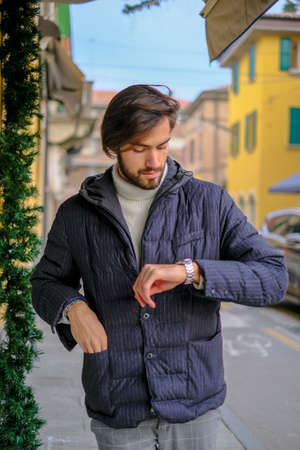 handsome Italian dark-haired boy with winter jacket walking. High quality photoの写真素材