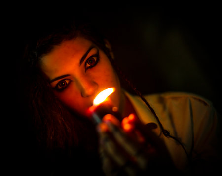 vampire dark goth girl with burning candles in a horror atmosphere. High quality photo