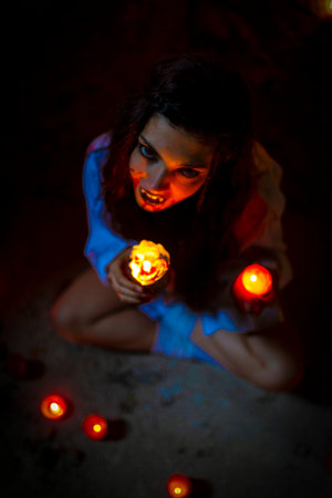 vampire dark goth girl with burning candles in a horror atmosphere. High quality photoの写真素材